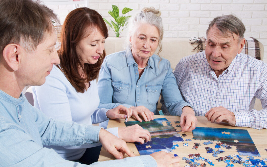 Middle-aged family elderly collects jigsaw puzzles at the table in the room