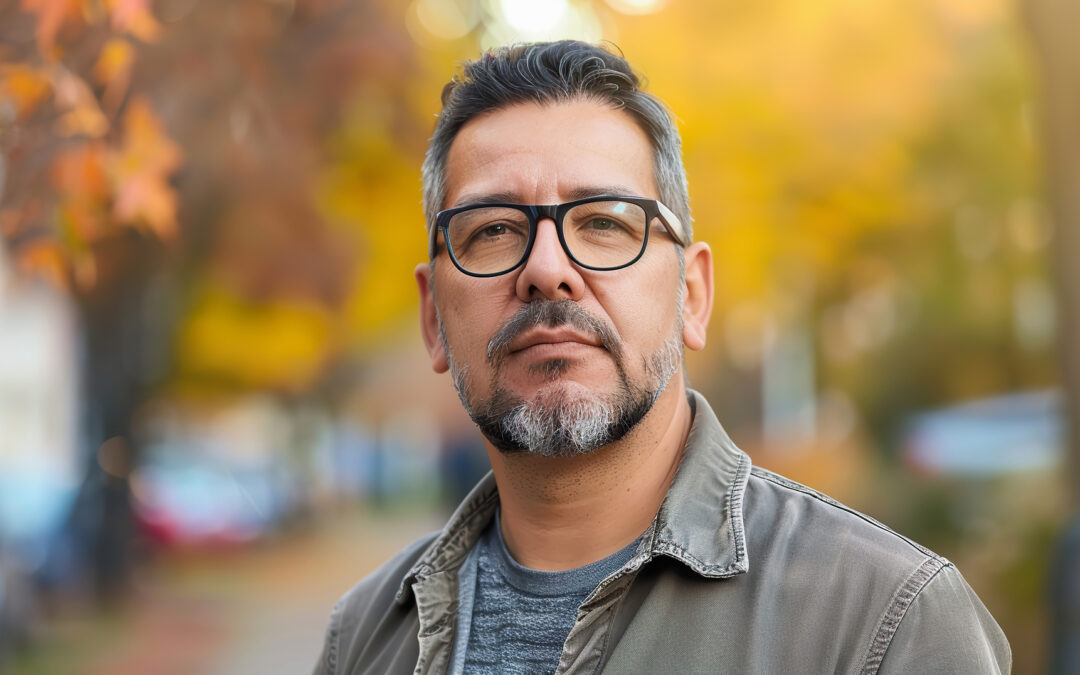 Middle aged Hispanic man standing seriously on an autumn street in casual clothing.