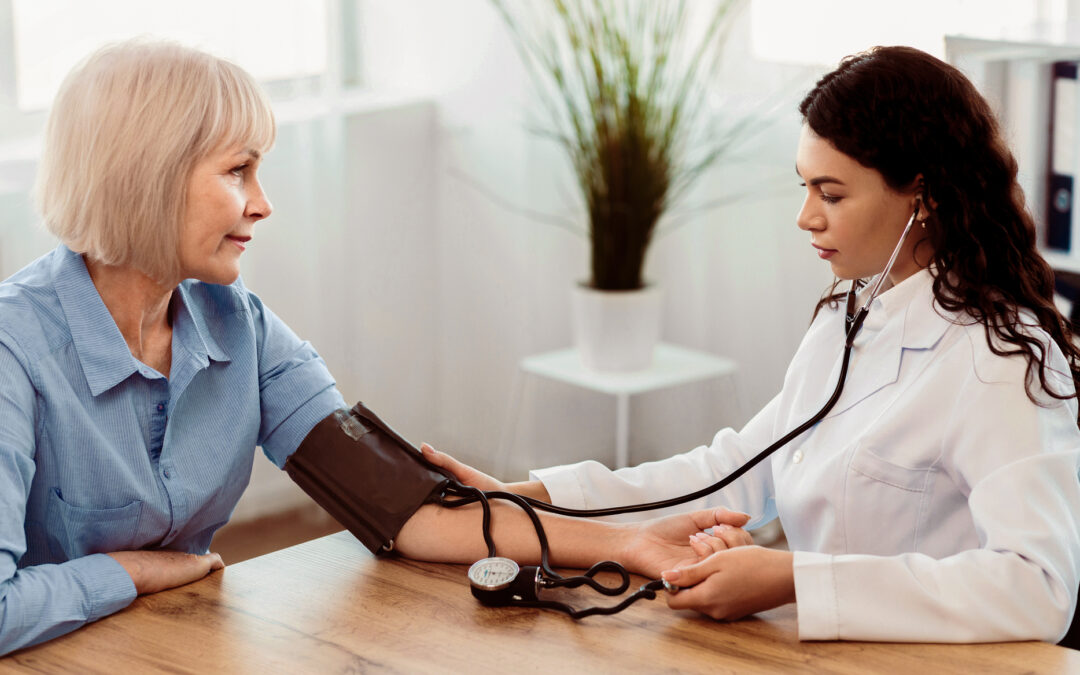 Cardiology. Mexican doctor measuring blood pressure of senior woman, checking patient, free space, panorama