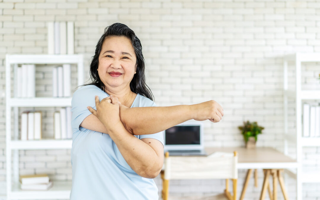 Morning work-out, Senior asian woman doing fitness exercises from home, Fitness woman doing stretch exercise stretching her arms, Elderly woman living an active lifestyle.